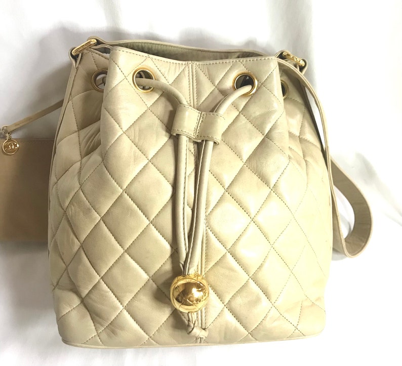 CHANEL Vintage beige quilted lamb leather hobo bucket shoulder bag with drawstrings and golden CC mark ball