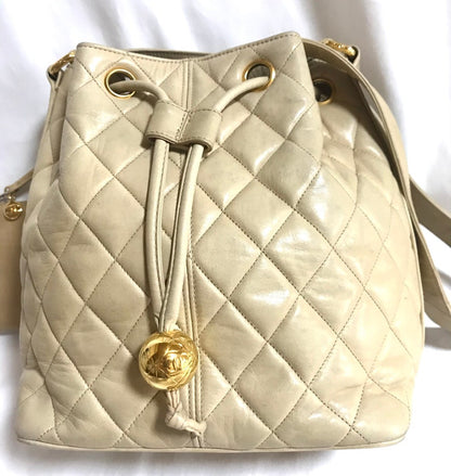 CHANEL Vintage beige quilted lamb leather hobo bucket shoulder bag with drawstrings and golden CC mark ball