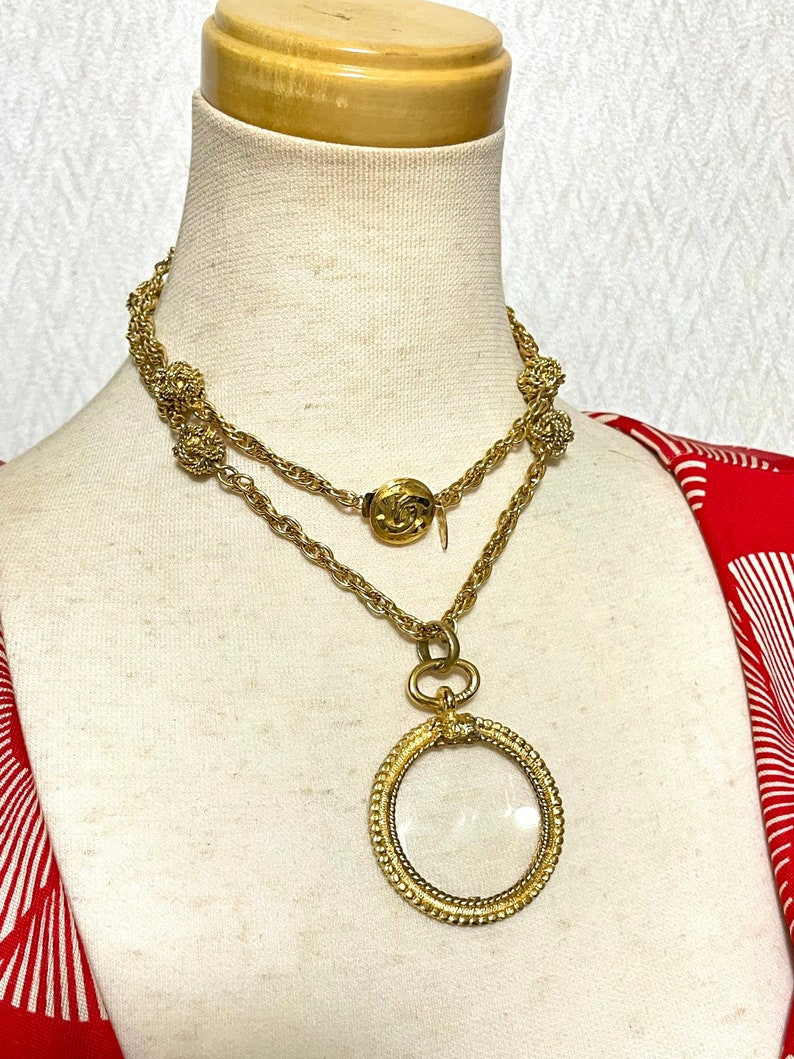 CHANEL Vintage golden chain necklace with loupe glass pendant top and ball charms