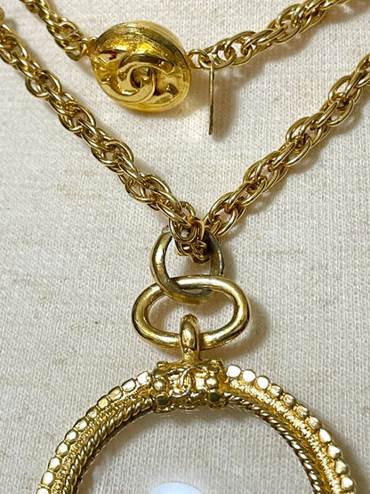 CHANEL Vintage golden chain necklace with loupe glass pendant top and ball charms