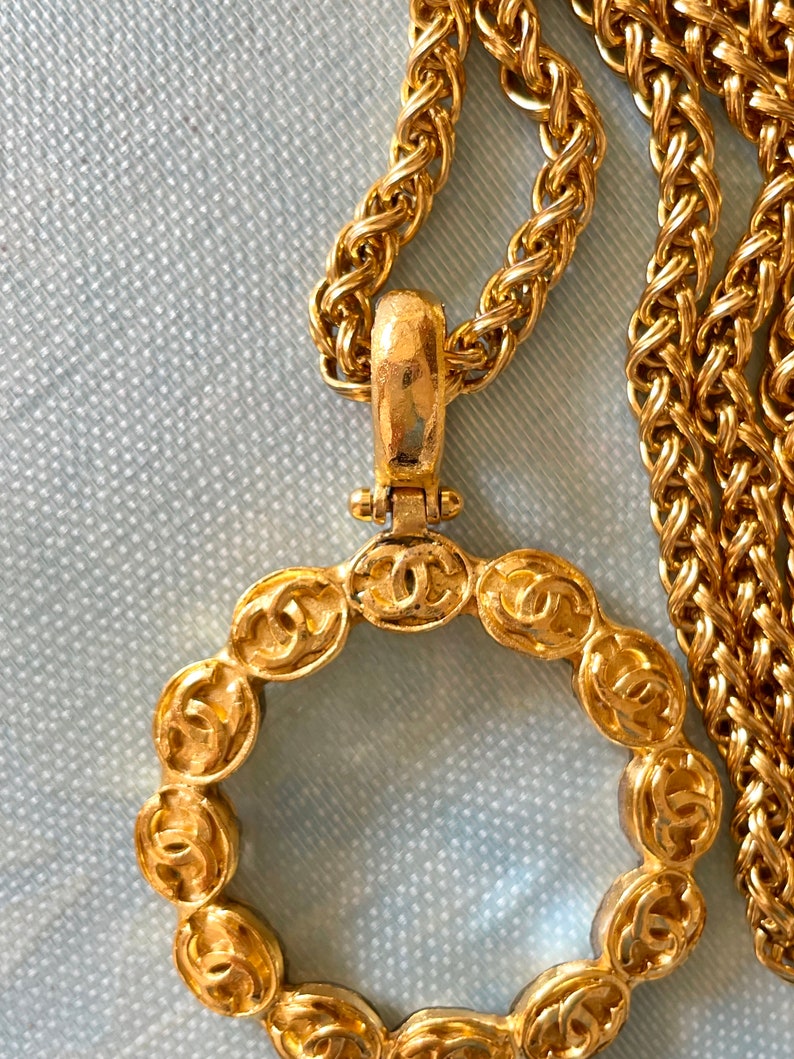 CHANEL Vintage long chain necklace with round glass loupe pendant top and CC motifs