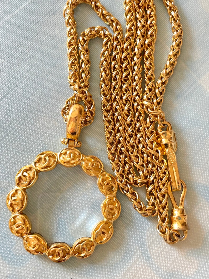 CHANEL Vintage long chain necklace with round glass loupe pendant top and CC motifs